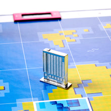 Load image into Gallery viewer, Model of a skyscraper on a grid-patterned surface with colorful shapes
